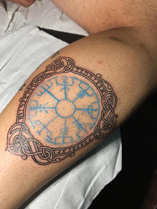 Tatuaje de fuerza y superación de una brújula vikinga en el gemelo