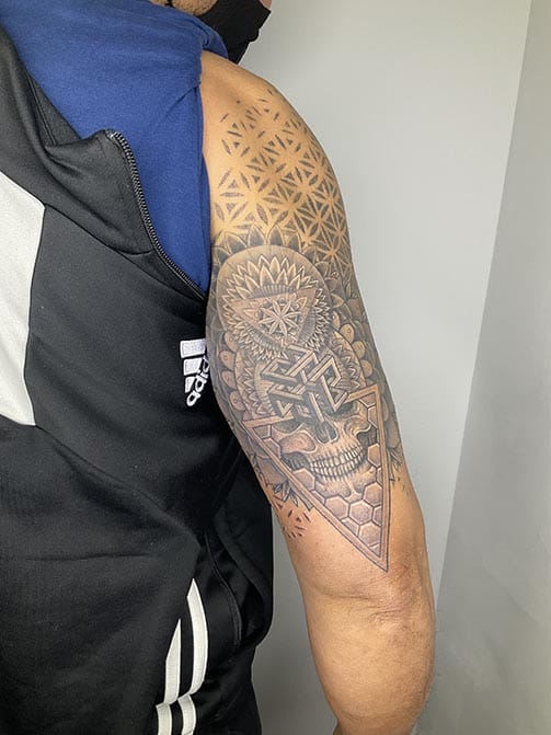 Tatuaje de hombre con significados espirituales o de conexión interior, geometría sagrada en el brazo