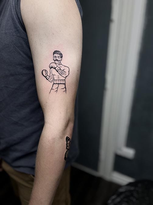 Tatuaje con significado minimalista para hombre de un luchador en el brazo