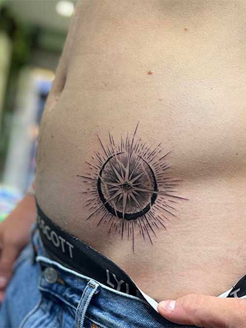 Tatuaje de hombre con significados espirituales o de conexión interior, ojo, sol y luna en la barriga