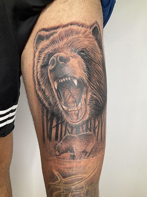 Tatuaje para hombre con significado espiritual de un oso en el muslo