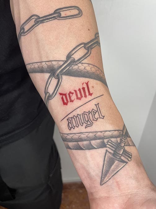 Tatuaje pequeño para hombre de palabras en el antebrazo "ángel y demonio"