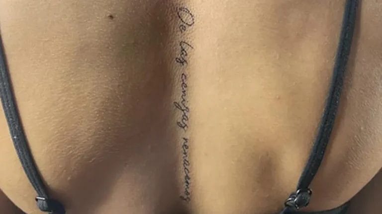 Tatuaje en la columna para mujer de una frase en la espalda