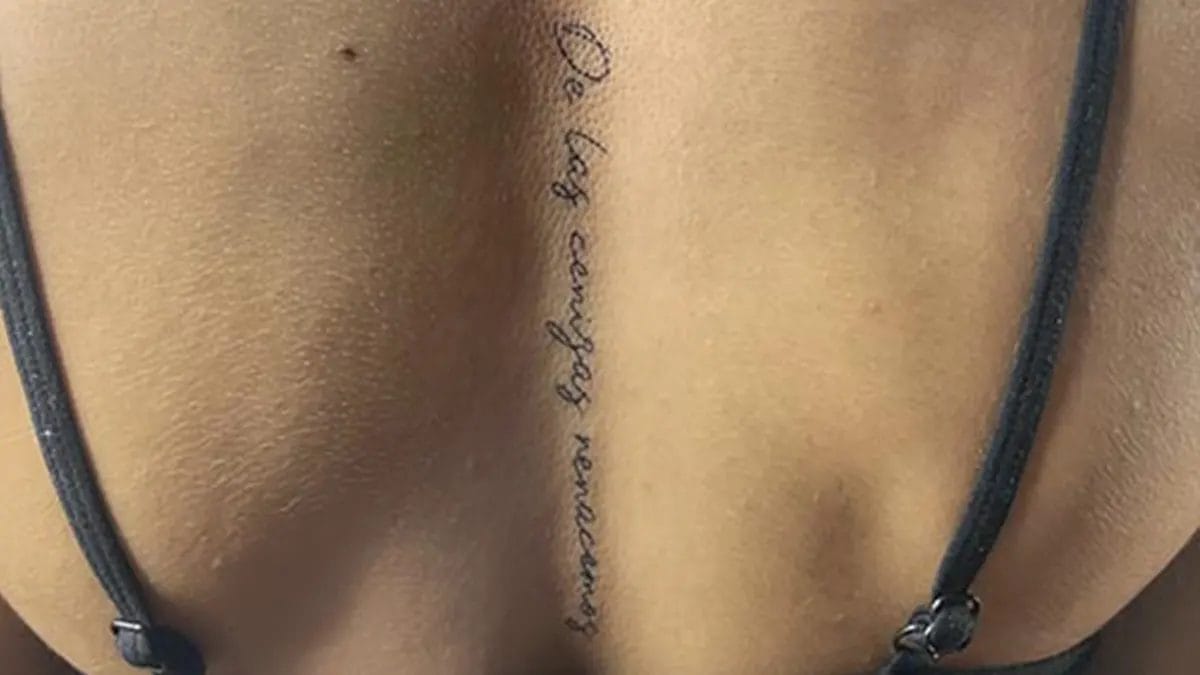 Tatuaje en la columna para mujer de una frase en la espalda