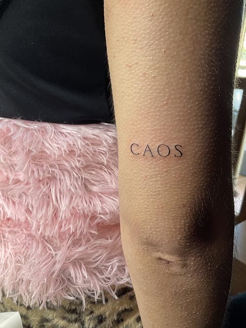 Tatuaje minimalista femenino de una palabra pequeña para mujer en el brazo