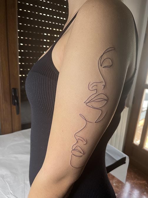 Tatuaje estilo fine line de la silueta de dos rostros