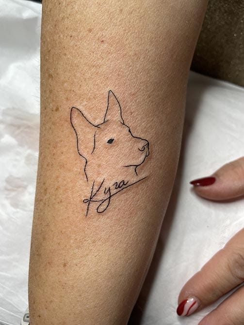 Tatuaje de la silueta de un perro o mascota con su nombre escrito