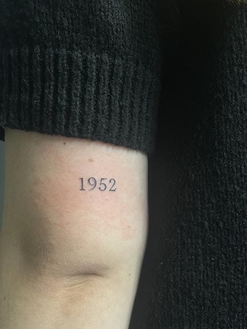 Tatuaje del año de nacimiento de un abuelo en el brazo