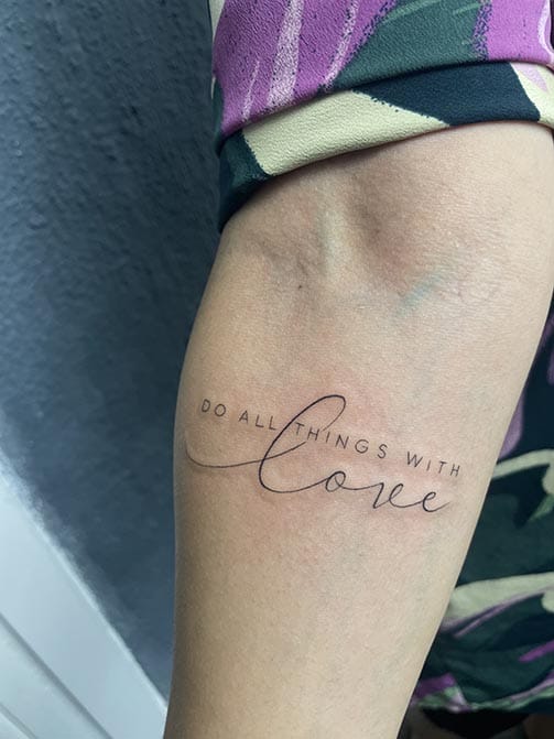 Tatuaje pequeño para mujer en el brazo de una frase en ingles