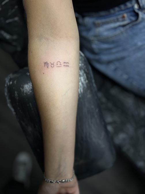 Tatuaje pequeño para mujer en el brazo de símbolos del zodiaco