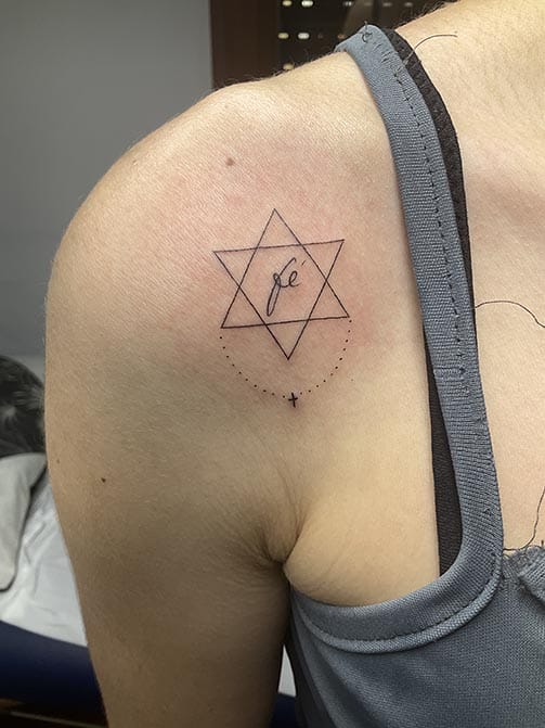 Tatuaje pequeño con significado para mujer de estrella con la palabra fe en el hombro