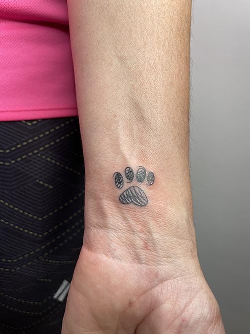 Tatuaje pequeño con significado para mujer de una huella en la muñeca