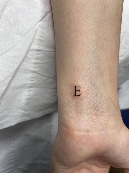 Tatuaje pequeño con significado para mujer  de una inicial en la muñeca