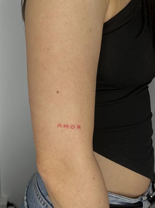 Tatuaje pequeño con significado para mujer  de la palabra amor en el brazo