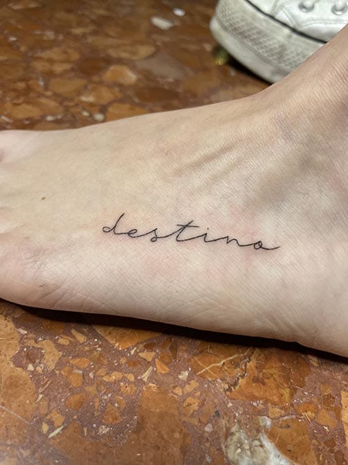 Tatuaje pequeño con significado para mujer  de una palabra en el pie