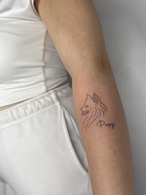 Tatuaje de la silueta de un perro o mascota con su nombre escrito